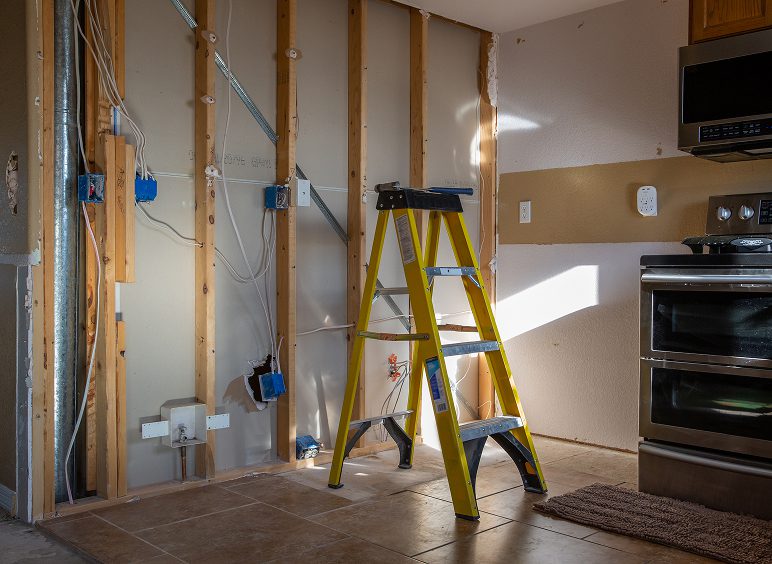 Yellow ladder in unfinished kitchen space
